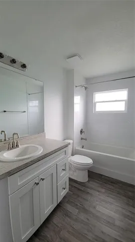 a bathroom with a granite countertop sink a toilet and a bathtub