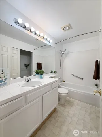 a bathroom with a double vanity sink toilet mirror and bathtub