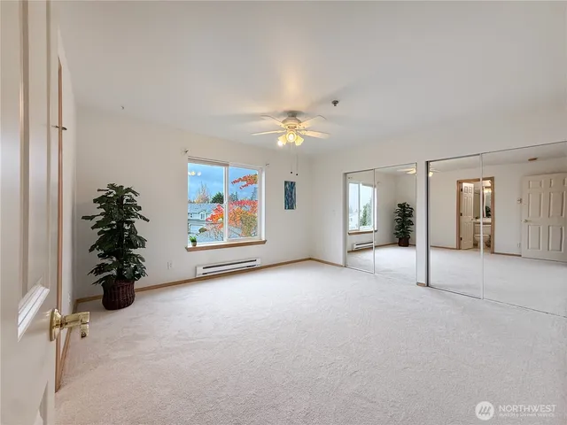 an empty room with windows and ceiling fan