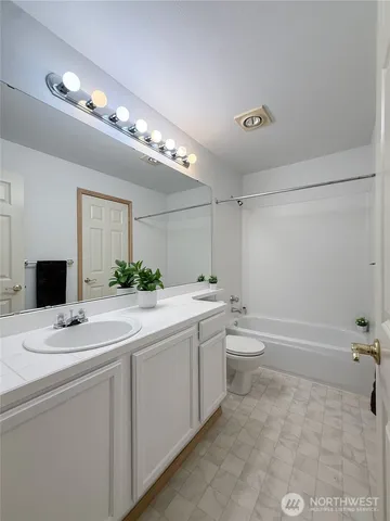 a bathroom with a granite countertop sink a toilet and a mirror