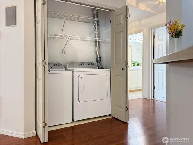 a utility room with cabinets and wooden floor