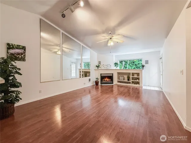 a view of a livingroom with furniture wooden floor and a ceiling fan