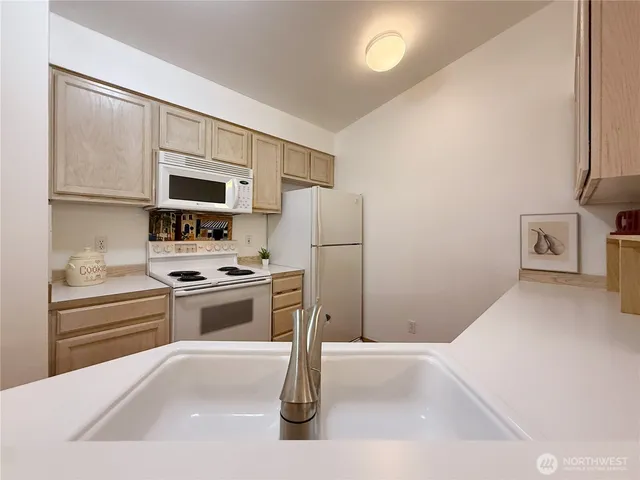 a kitchen with stainless steel appliances granite countertop a refrigerator sink and stove