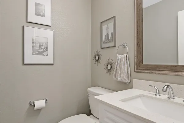 a bathroom with a sink mirror and toilet