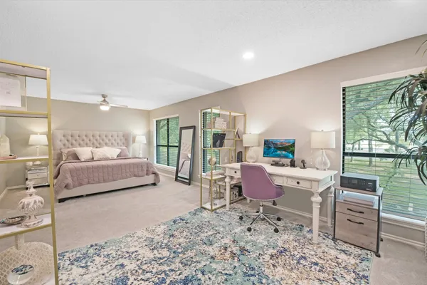 a bedroom with furniture and a large window