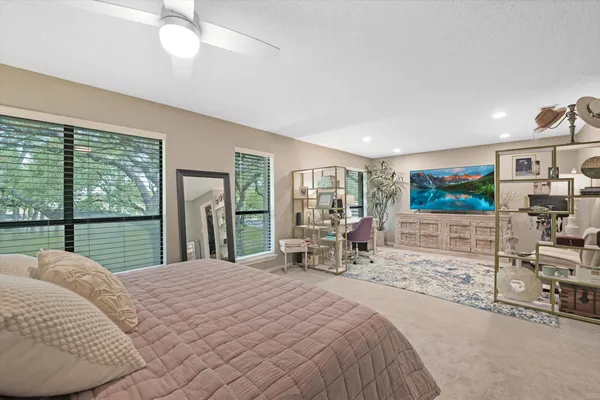 a bedroom with a bed and large windows
