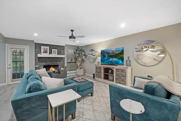 a living room with furniture a flat screen tv and a fireplace