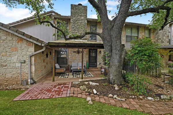 a view of a chair and table in backyard of the house