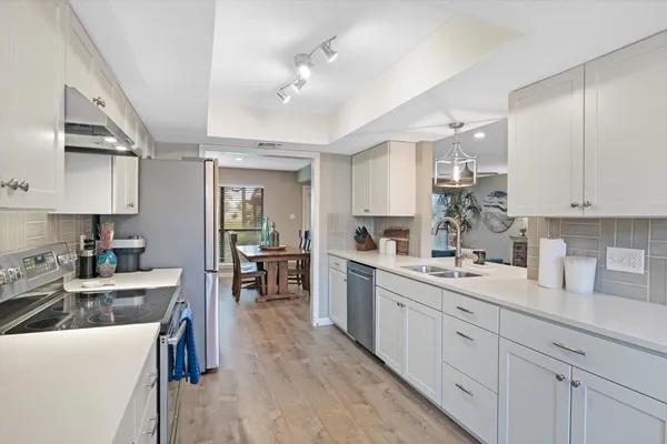 a kitchen with sink stove and cabinets