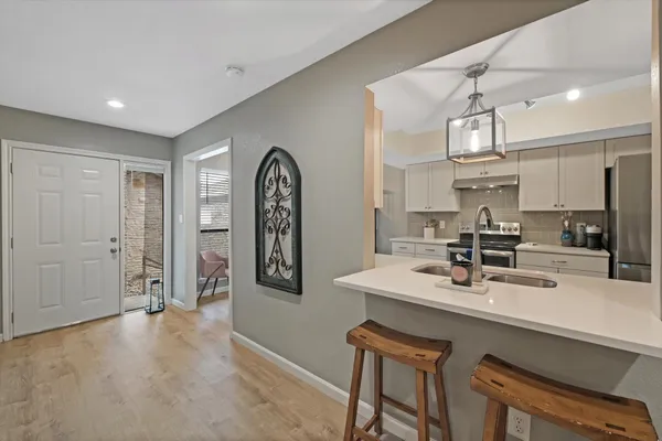 a kitchen with stainless steel appliances kitchen island granite countertop a sink cabinets and wooden floor