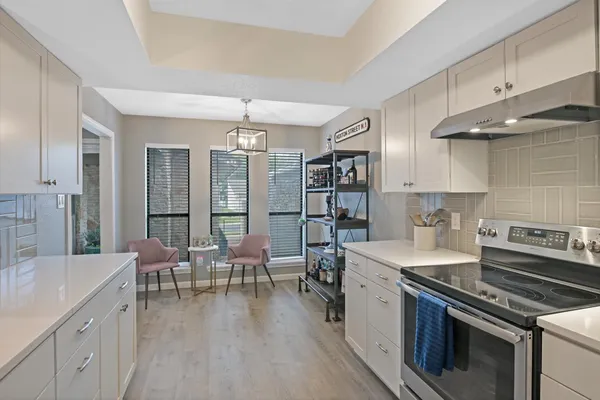 a open kitchen with stainless steel appliances granite countertop a stove and chairs