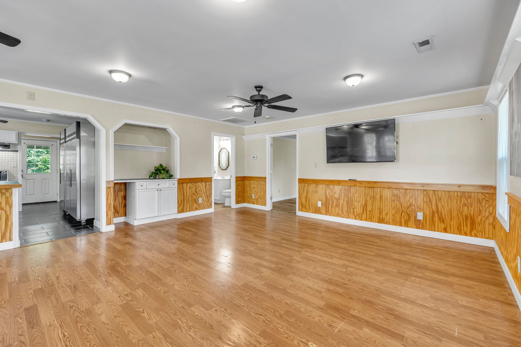 427 Telegraph Street Tennessee Ridge, TN 37178 - Photo 12 of 47 a view of a livingroom with a flat screen tv wooden floor and a ceiling fan