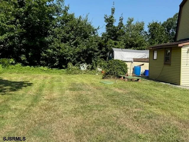 a view of backyard with barbeque grill and wooden fence