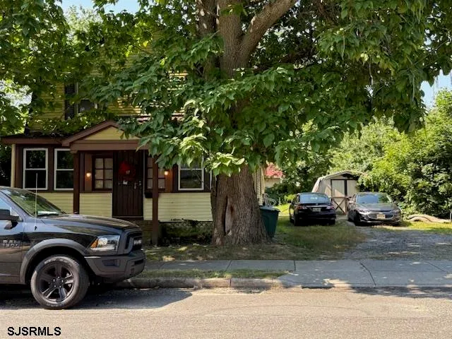 a front view of a house with a garden and parking