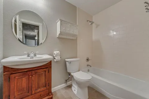 a bathroom with a sink toilet vanity and shower