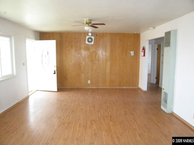 6555 Curry Road Fallon, NV 89406 - Photo 3 of 9 a view of an empty room with wooden floor and a window