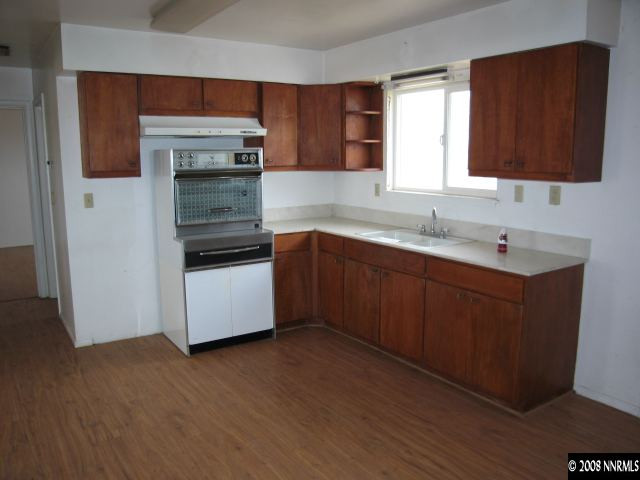6555 Curry Road Fallon, NV 89406 - Photo 4 of 9 a kitchen with stainless steel appliances a sink and wooden floor