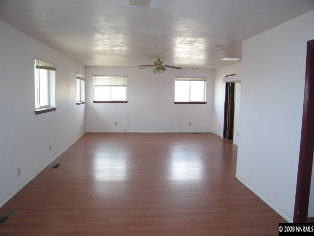 6555 Curry Road Fallon, NV 89406 - Photo 6 of 9 an empty room with wooden floor and windows