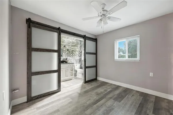 a view of a kitchen with a refrigerator a ceiling fan and wooden floor