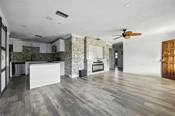 a kitchen with granite countertop a refrigerator and a stove top oven
