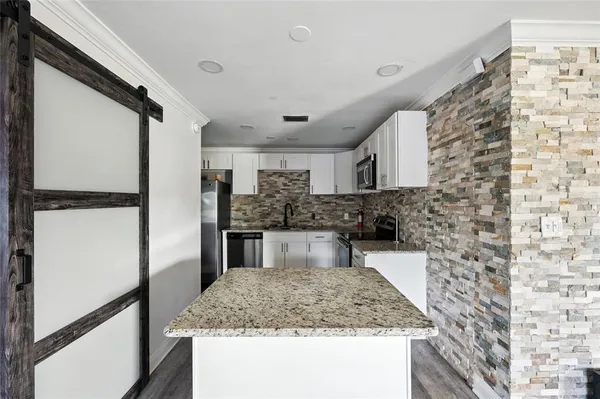 a kitchen with kitchen island a sink and refrigerator