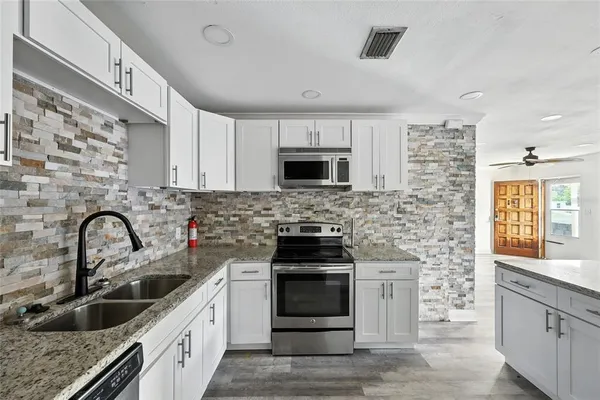 a kitchen with sink a stove and microwave