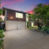 a view of a house with a yard and potted plants