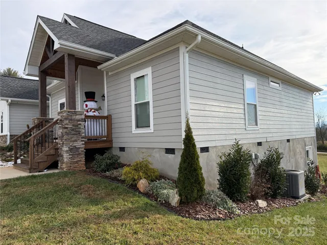 a front view of house with yard and trees in the background