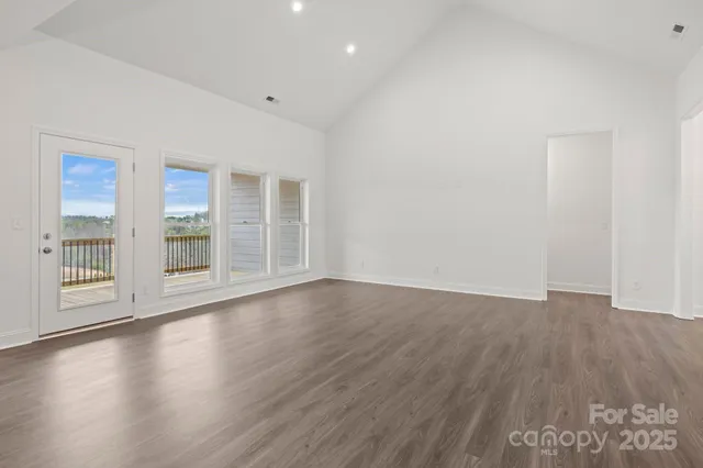 a kitchen with stainless steel appliances granite countertop a refrigerator a sink dishwasher a stove and a refrigerator with wooden floor