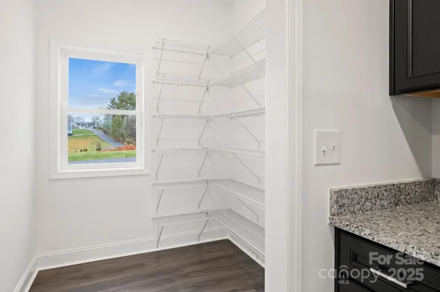 an empty room with wooden floor & windows