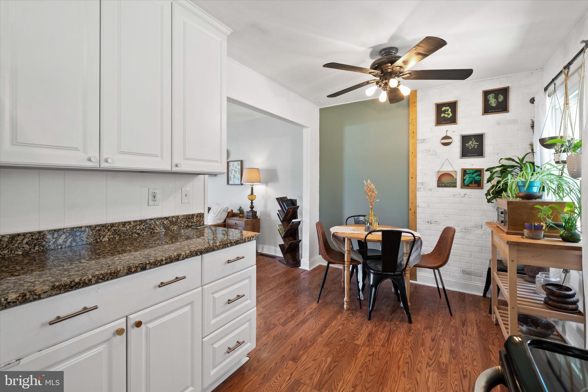 141 West Rutherford Drive Newark, DE 19713 - Photo 11 of 30 a kitchen with granite countertop a dining table chairs and white cabinets