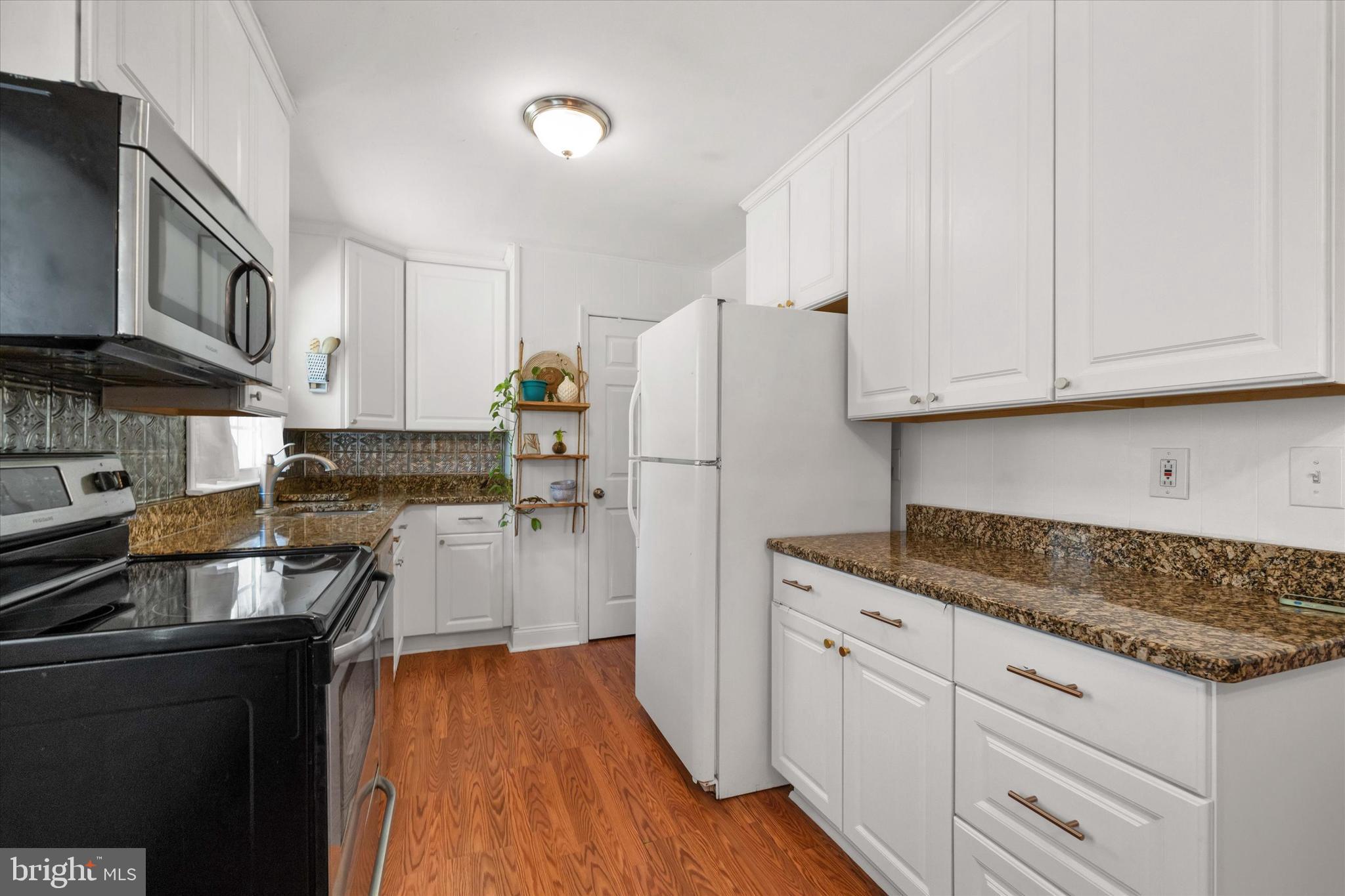 141 West Rutherford Drive Newark, DE 19713 - Photo 12 of 30 a kitchen with granite countertop white cabinets and stainless steel appliances