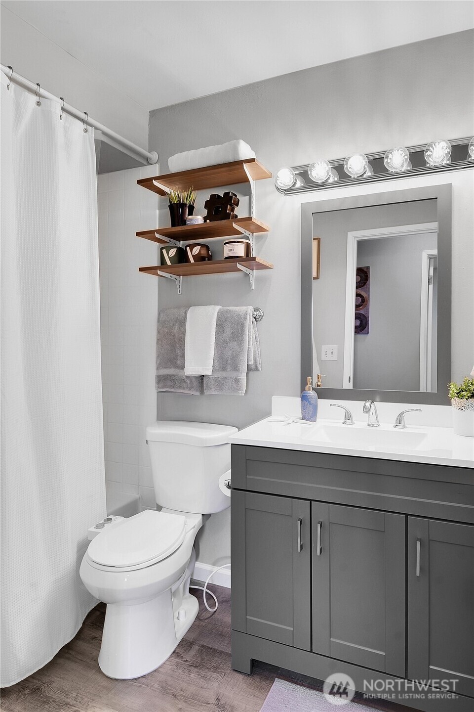 2562 Thorndyke Avenue West, Unit 104 Seattle, WA 98199 - Photo 12 of 18 a bathroom with a sink a toilet and mirror