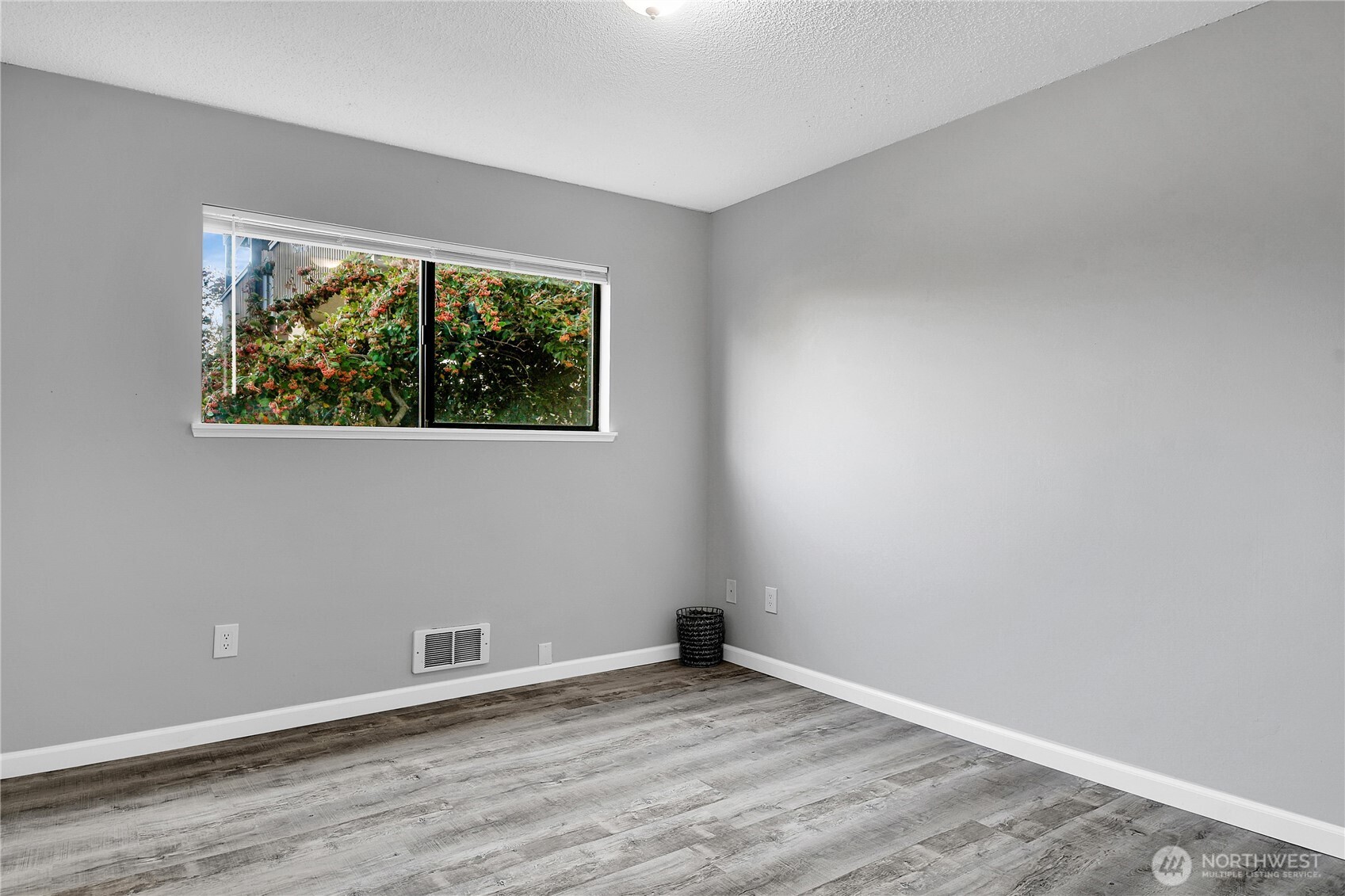 2562 Thorndyke Avenue West, Unit 104 Seattle, WA 98199 - Photo 14 of 18 an empty room with wooden floor and windows