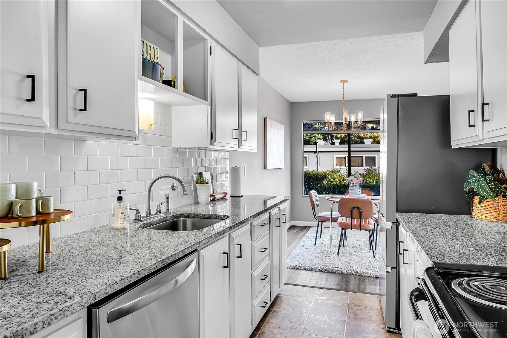 2562 Thorndyke Avenue West, Unit 104 Seattle, WA 98199 - Photo 6 of 18 a kitchen with stainless steel appliances granite countertop a sink a stove and a refrigerator