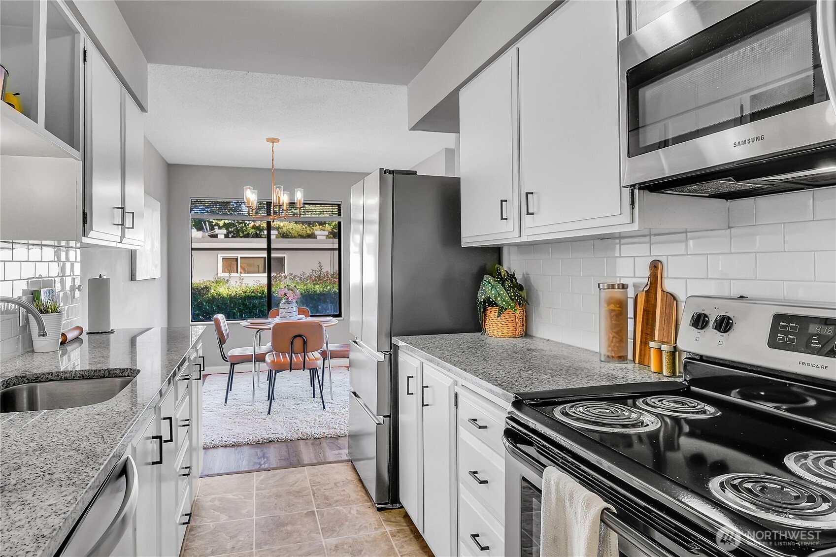 2562 Thorndyke Avenue West, Unit 104 Seattle, WA 98199 - Photo 7 of 18 a kitchen with stainless steel appliances granite countertop a sink stove and cabinets