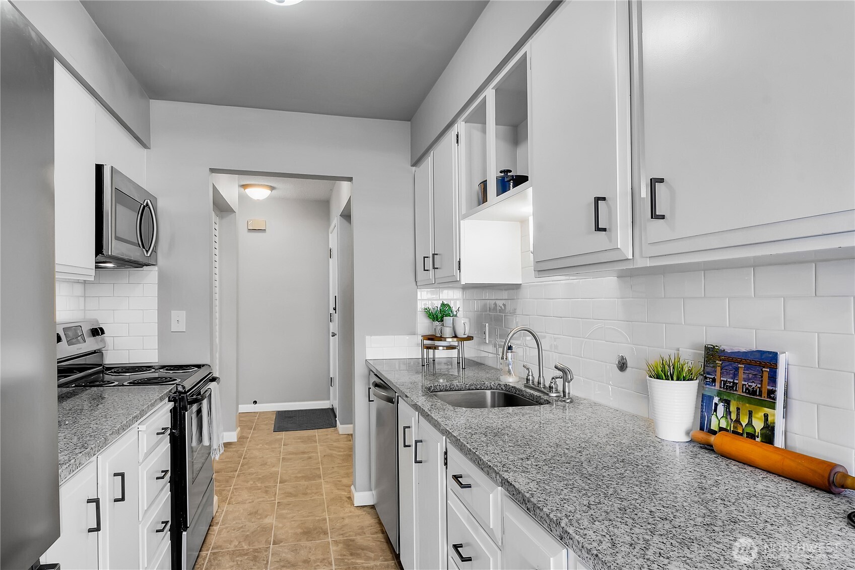 2562 Thorndyke Avenue West, Unit 104 Seattle, WA 98199 - Photo 8 of 18 a kitchen with granite countertop a sink a stove and cabinets