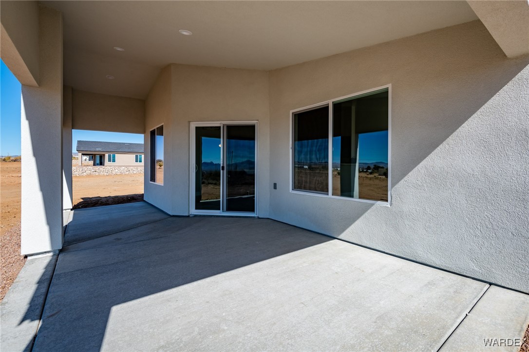3355 North Bryce Road Golden Valley, AZ 86413 - Photo 23 of 31 a view of an empty room with wooden floor and windows