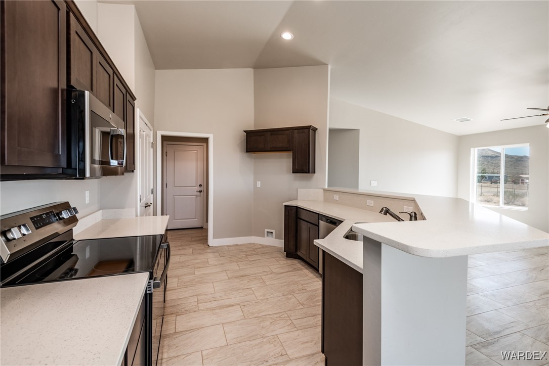 3355 North Bryce Road Golden Valley, AZ 86413 - Photo 27 of 31 a kitchen that has a sink and a stove in it