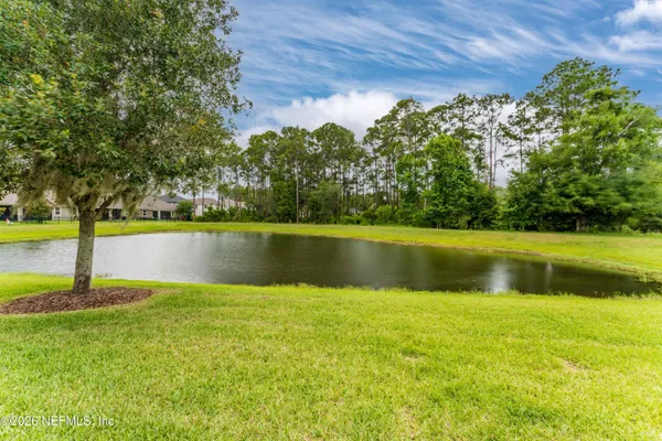 a kitchen with stainless steel appliances a sink a stove a refrigerator white cabinets and wooden floor