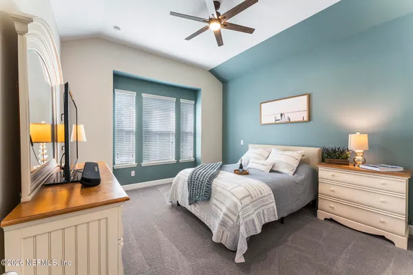 a living room with furniture a flat screen tv and a large window