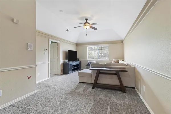 a living room with furniture a window and a ceiling fan