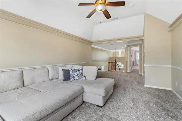 a living room with furniture and a ceiling fan