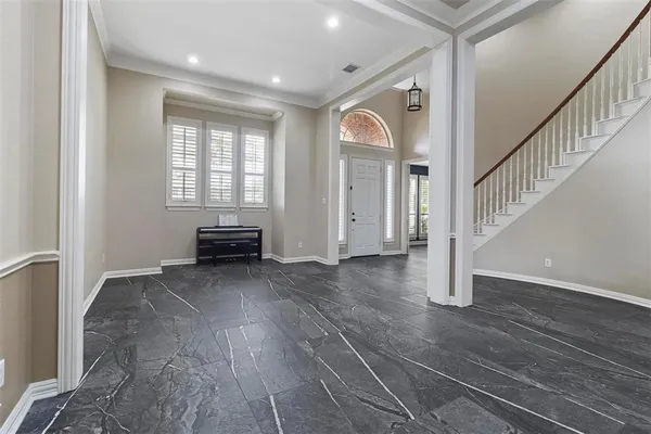 a view of an empty room with wooden floor and stairs