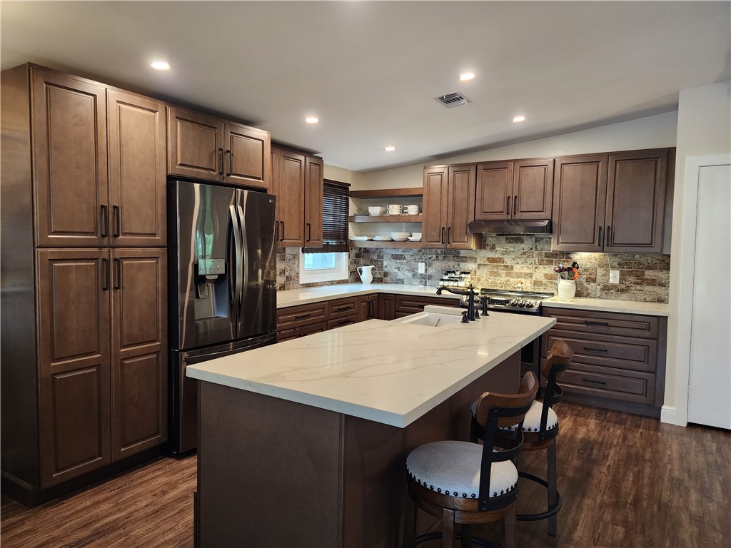a kitchen with kitchen island a sink stove and refrigerator