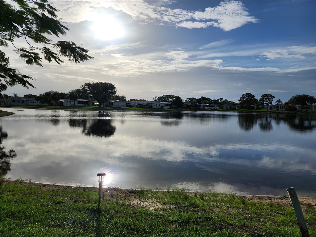 256 Bimini Cay Circle Vero Beach, FL 32966 - Photo 3 of 35 a view of a lake in front of house with outdoor seating