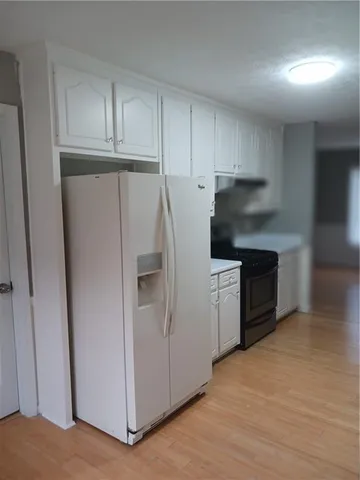 a kitchen with a refrigerator sink and cabinets