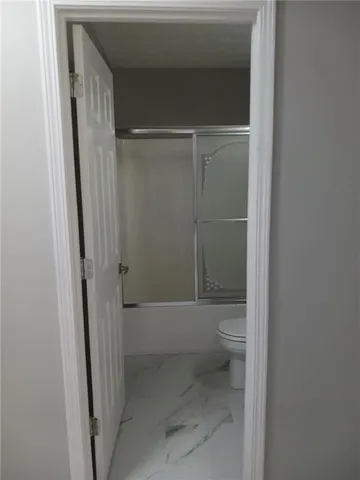 a bathroom with a toilet and a shower