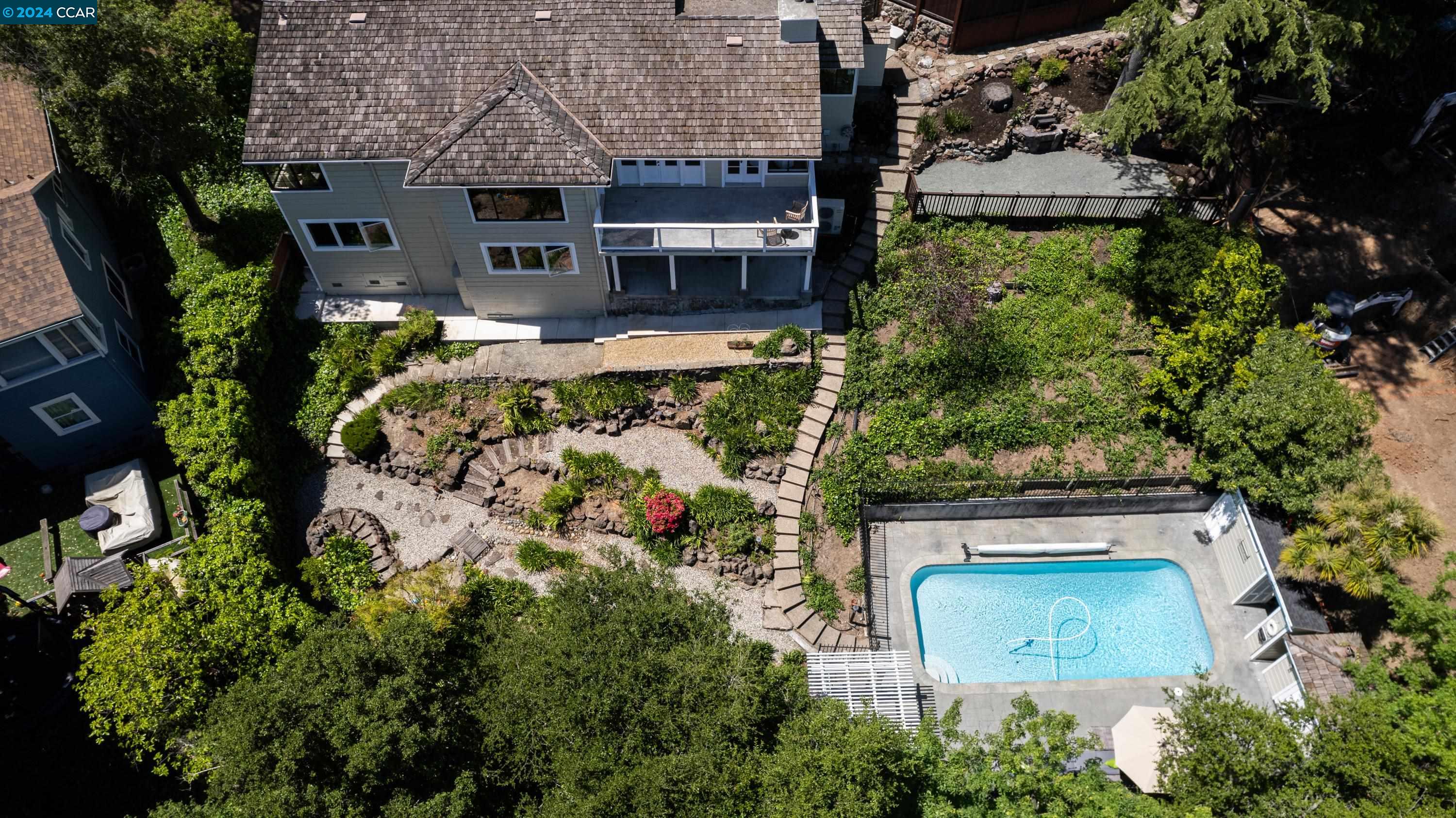 an aerial view of a house with garden space sitting area and large tree