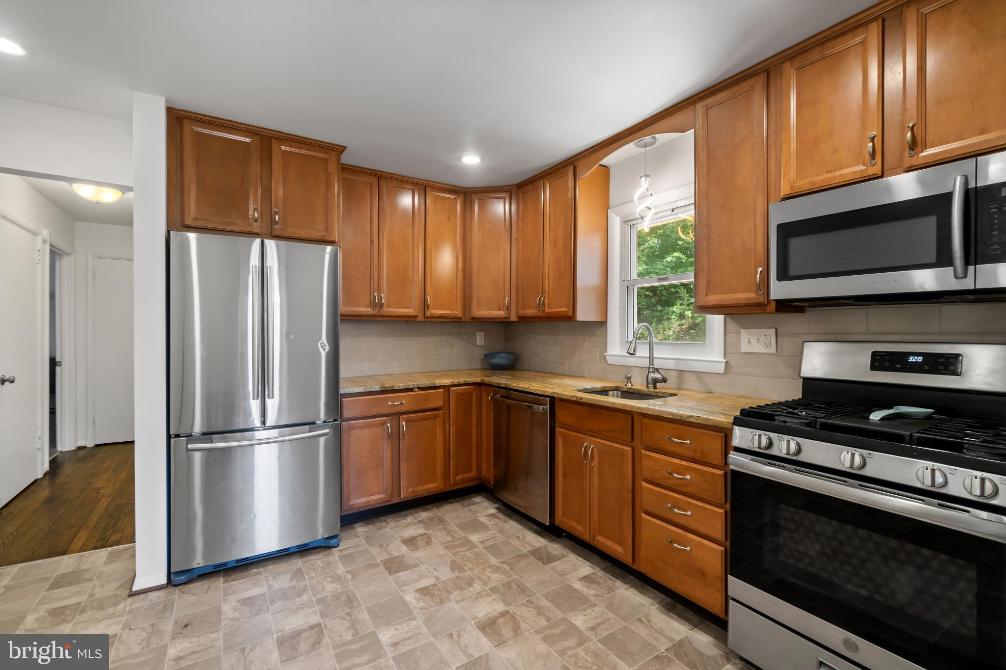 415 Baylor Road Glen Burnie, MD 21061 - Photo 7 of 29 a kitchen with stainless steel appliances granite countertop a refrigerator stove top oven microwave and sink